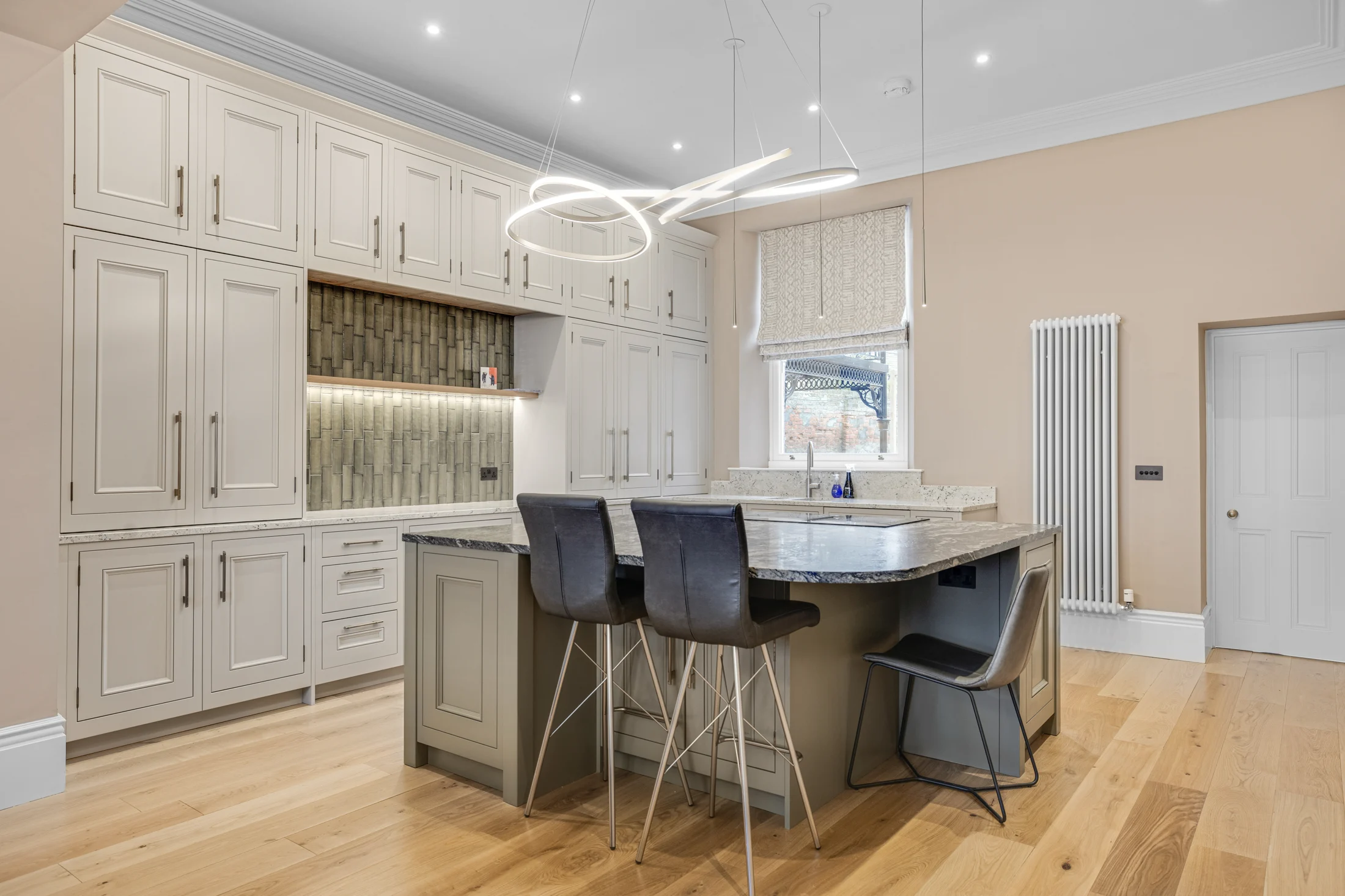 The completed Percy Gardens kitchen with its marble island and sculptural pendant lighting