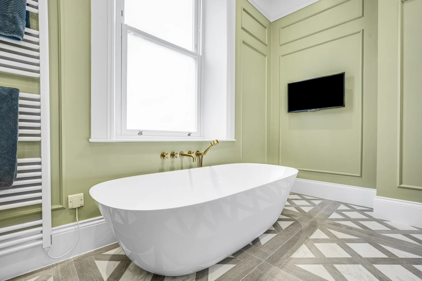 Freestanding bath and decorative floor tiles at Percy Gardens